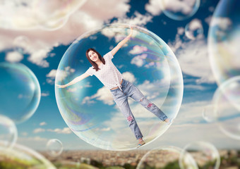 Pretty woman flying in the sky in big soap bubble