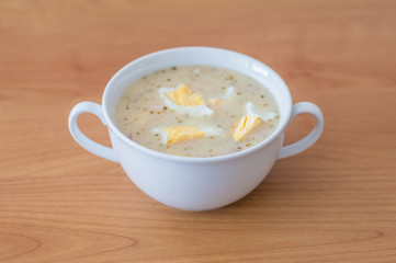 Polish traditional soup zurek in white bowl.