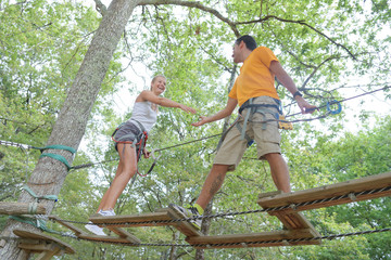 young couple having fun on a rope bridge