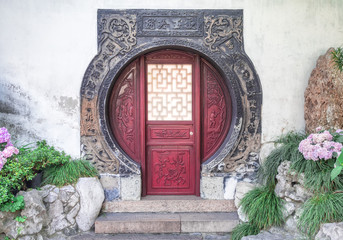 Traditional chinese circular red door with wooden ornaments at Yu Gardens, Shanghai, China