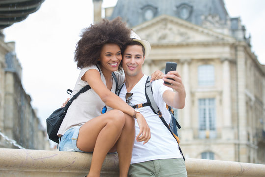 couple taking selfie in front of a building