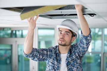 Man fitting roof insulation