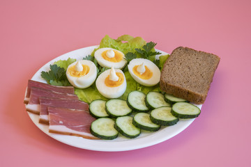 breakfast. Boiled eggs, bacon, greens in a white plate on pink background. White plate with food on a pink background