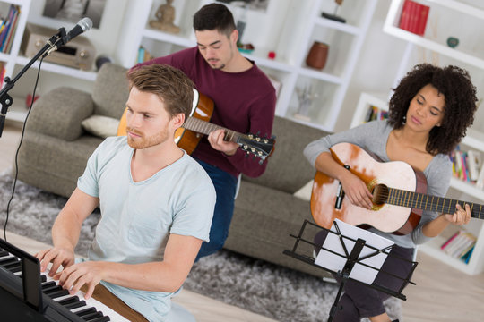 multiracial music band rehearsing at home