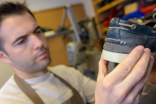 Cobbler holding a deck shoe