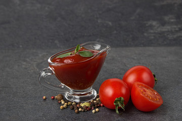 glass sauce-boat. gravy boat. tomato sauce on a black