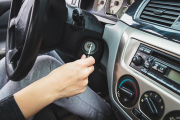 The girl starts the car, inserting the ignition key.