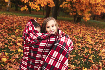 Two cute sisters playing in autumn park