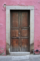 Old wood Mexican colonial door with pink wall in Guanajuato Mexico	