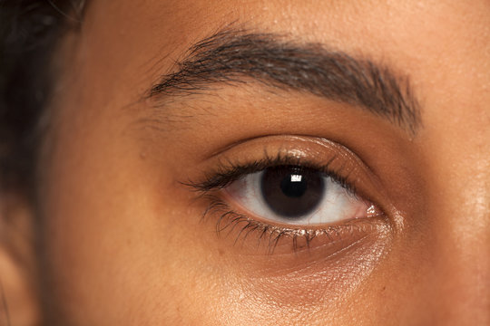 natural eyebrow and eye without makeup of dark skinned female