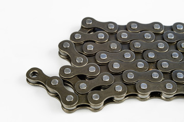 Fototapeta na wymiar Bike chain arranged on a white table. Periodic servicing of parts for two-wheelers.