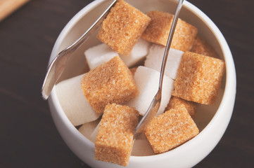 Sugar Bowl with cubes of white cane sugar, sugar-tongs and napkins. Atmosphere and table appointments in the city cafe