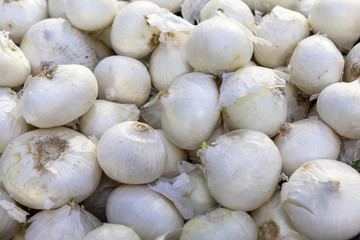 Red onions are laid out on shop windows.