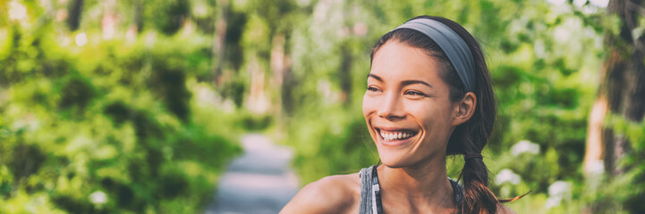 Happy young Asian woman outdoor walking in park smiling living an active and healthy lifestyle....