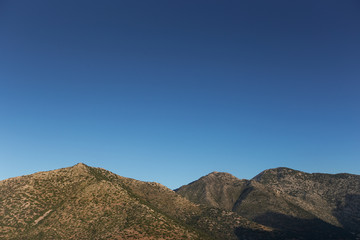 Evening mountains in the blue gradient cloudless sky
