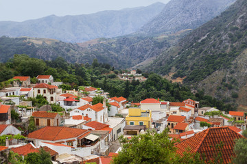 Fototapeta na wymiar White houses with red roofs in the mountains, Argiroupolis, Crete