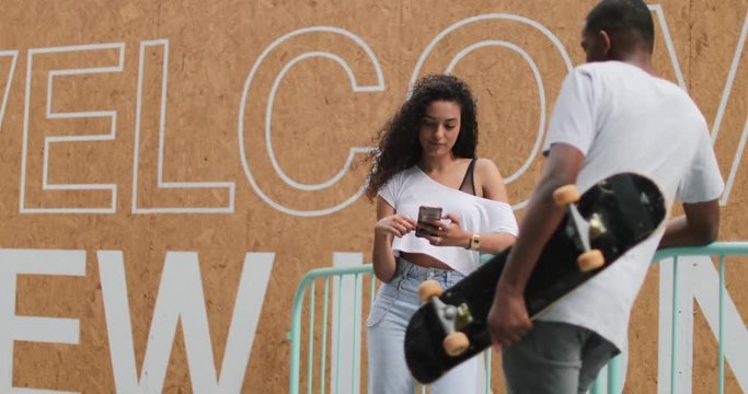 Teenagers socialising outdoors in city with smartphone