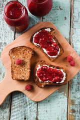 Tasty summer breakfast. Homemade berry jam on ciabatta toasts on old shabby blue boards