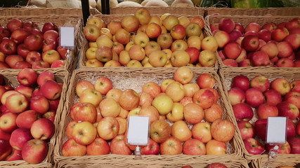 Wicker basket with raw organic apples on autumnal seasonal farmers market