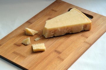 grana padano cheese on wooden chopping board
