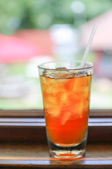 Drink for hot summer days. Fresh ice tea  in a glass on a wooden desk