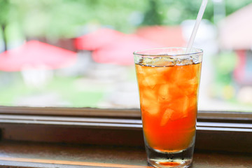 Drink for hot summer days. Fresh ice tea  in a glass on a wooden desk