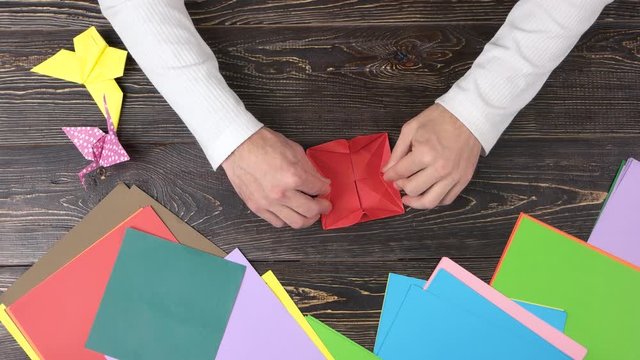 Talent and creativity. Close up male hands folding origami figure.