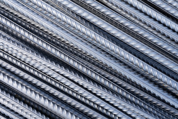 Stack of heavy metal reinforcement bars with periodic profile texture. Close up steel construction armature. Abstract industrial background concept. Copy space.