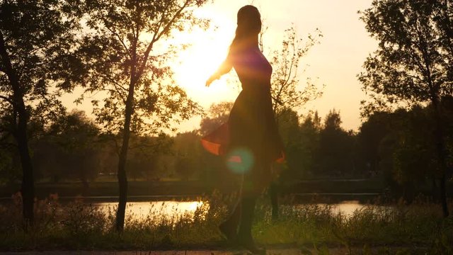 Woman in red dress body silhouette against sun