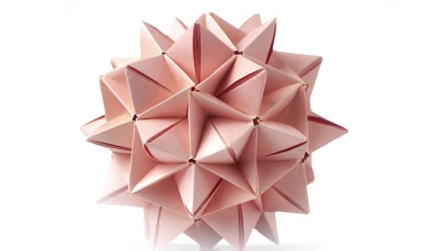Beige origami transforming spiky ball. Origami exhibition, rotating figure.