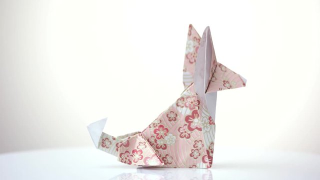 Origami fox close up. Decorated paper. White isolated background.