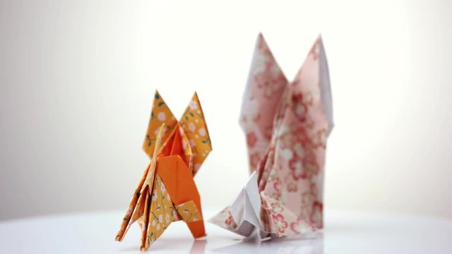 Two origami foxes. Cute designed paper figurines of animals.