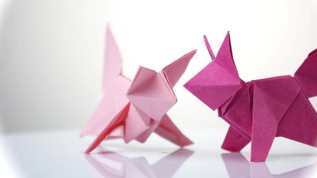 Purple origami foxes. White isolated background. Origami exposition.