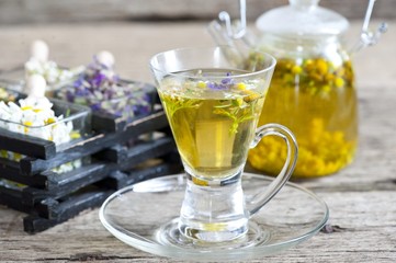 Cup of herbal tea with wild flowers and various herbs 