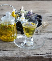 Cup of herbal tea with wild flowers and various herbs 