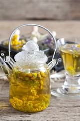 Cup of herbal tea with wild flowers and various herbs 