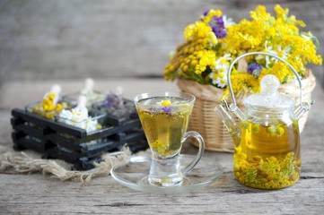 Cup of herbal tea with wild flowers and various herbs 