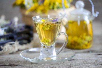 Cup of herbal tea with wild flowers and various herbs 