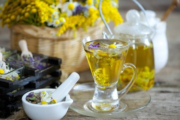 Cup of herbal tea with wild flowers and various herbs 