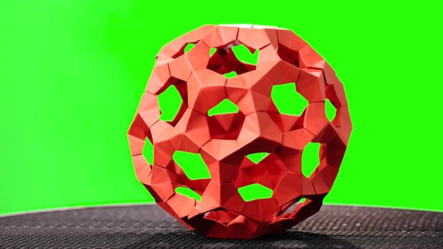Red rotating modular origami. Green hromakey background for keying.