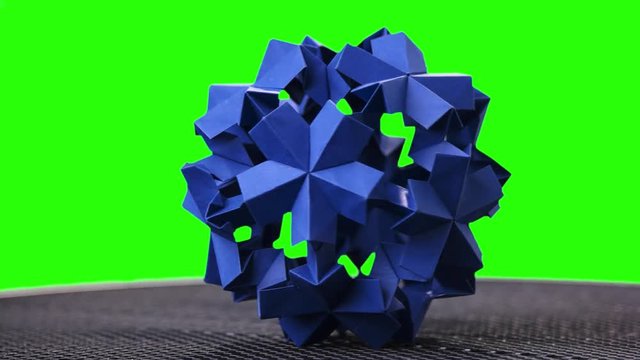 Blue origami spiky ball exposition. Green hromakey background for keying.
