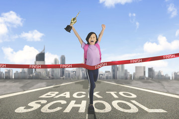 Happy schoolgirl crossing the finish line