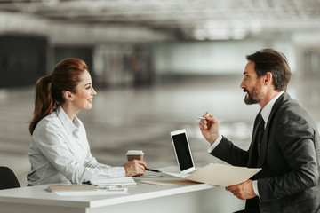 Side view beaming girl talking with outgoing bearded businessman. He gesticulating hands and...