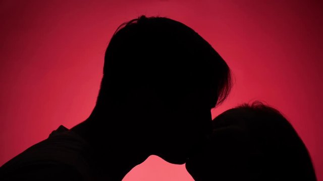 color background. 4k, slow motion. shadow of a man. couple, man and woman kissing