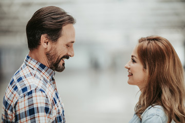 Side view smiling bearded man telling with cheerful girl. Happy conversation concept