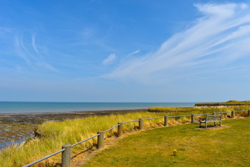 Fototapeta na wymiar Bench ideally overlooking Minnis Bay Beach. Plan a great day out. Birchington, Kent, UK