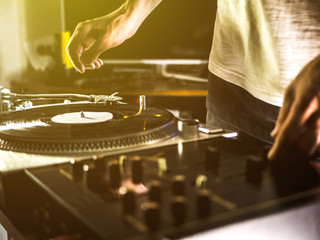 close up dj hand play music on turntable record setup at home party tomed vintage look