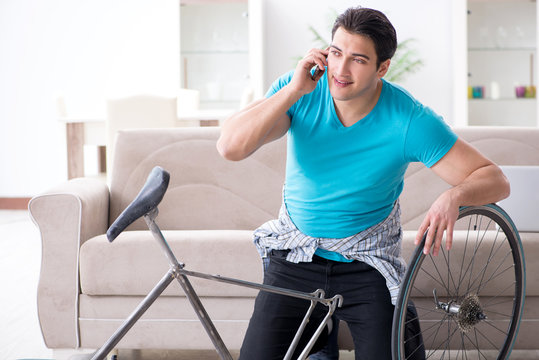 Young man repairing bicycle at home