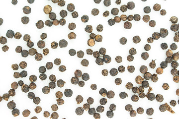 black peppercorns heap top view on white background.