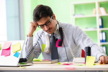 Young help desk operator working in office with many conflicting